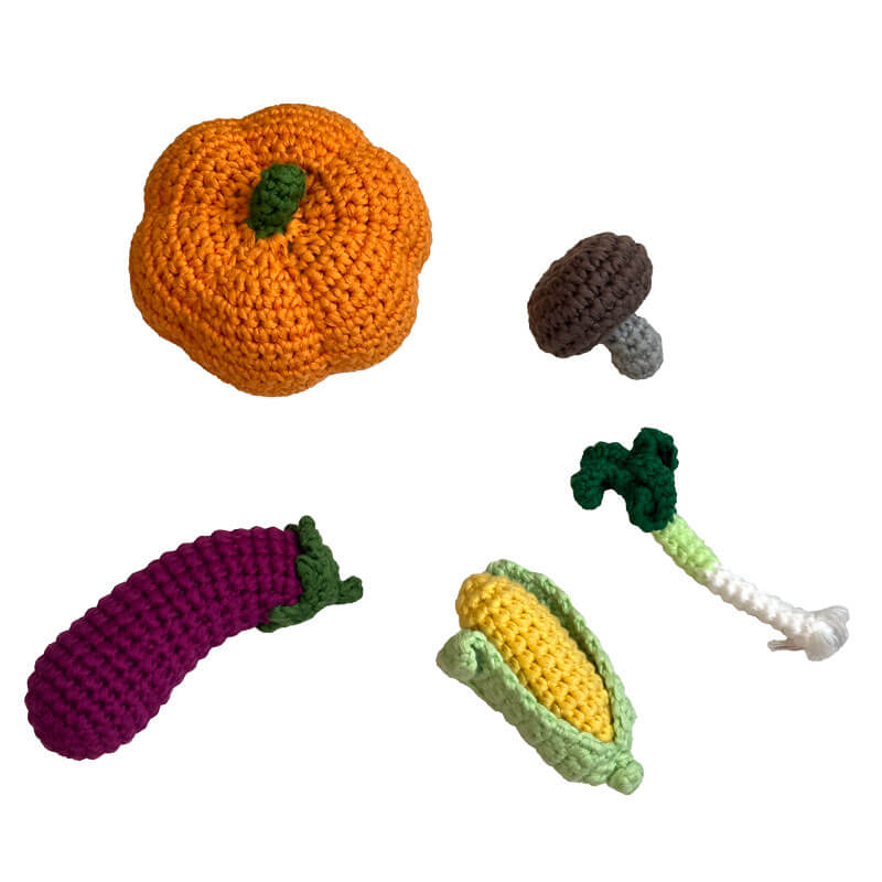 Handgehäkeltes Mini-Gemüse Set aus Bio-Baumwolle mit Lauch, Aubergine, Kürbis, Mais und Pilzen in einem Fairtrade-Netzbeutel. Nachhaltiges Spielzeug zur Förderung der Kreativität bei Kindern.